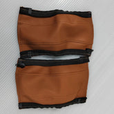 Pair of brown leather stroller handle covers on a white background