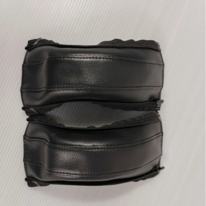 Pair of black leather stroller handle covers on a white background
