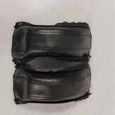 Pair of black leather stroller handle covers on a white background