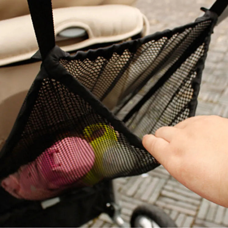 Black mesh car organizer with colorful items inside, held by a hand.