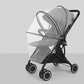 Black baby stroller with transparent rain cover on a gray background