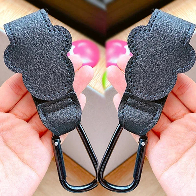 Black leather keychain carabiners held in hands with a blurred background