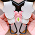 Two beige leather straps with black carabiners held by hands against a neutral background.