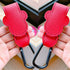 Red leather straps with black carabiners held by hands on a blurred background